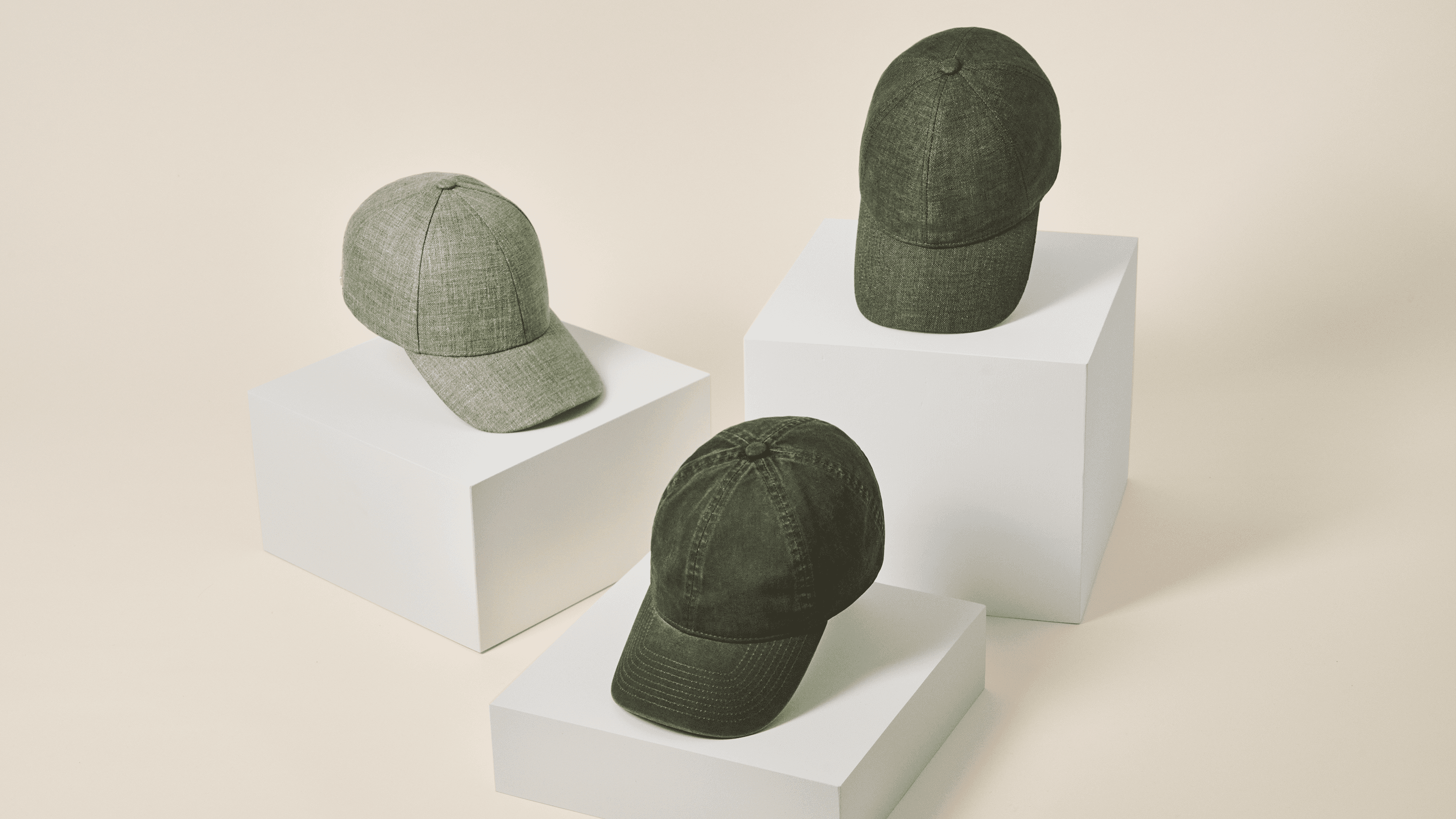 Front view of three green baseball caps in linen and cotton materials