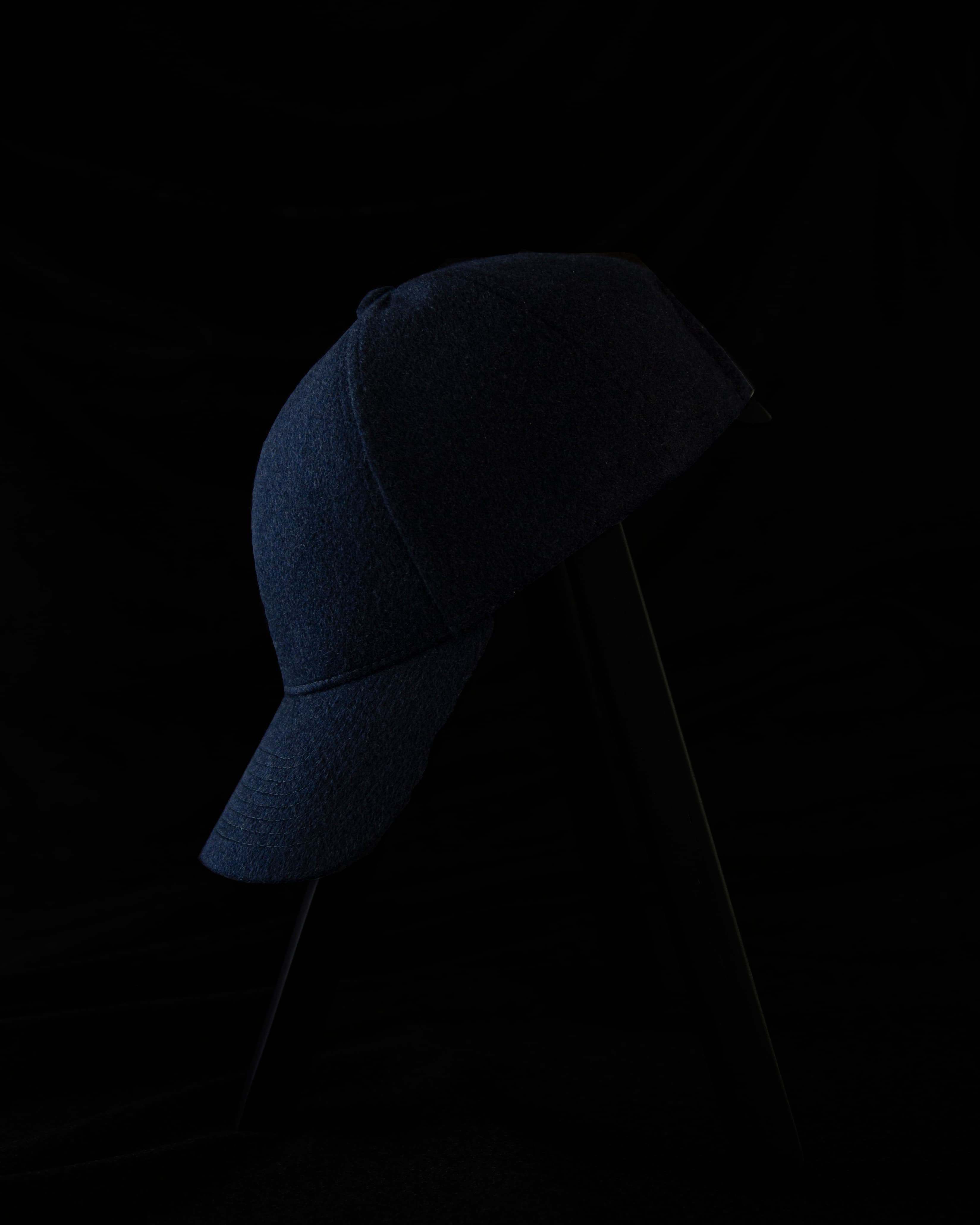 Side view dark studio image of navy cap